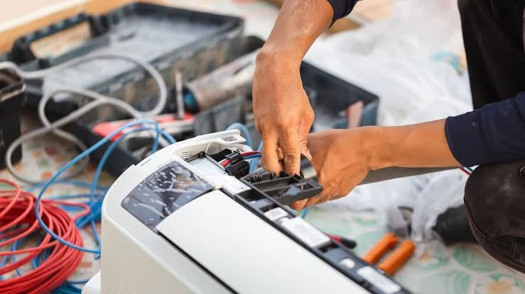 Close-up of a technician inspecting indoor air-conditioning components